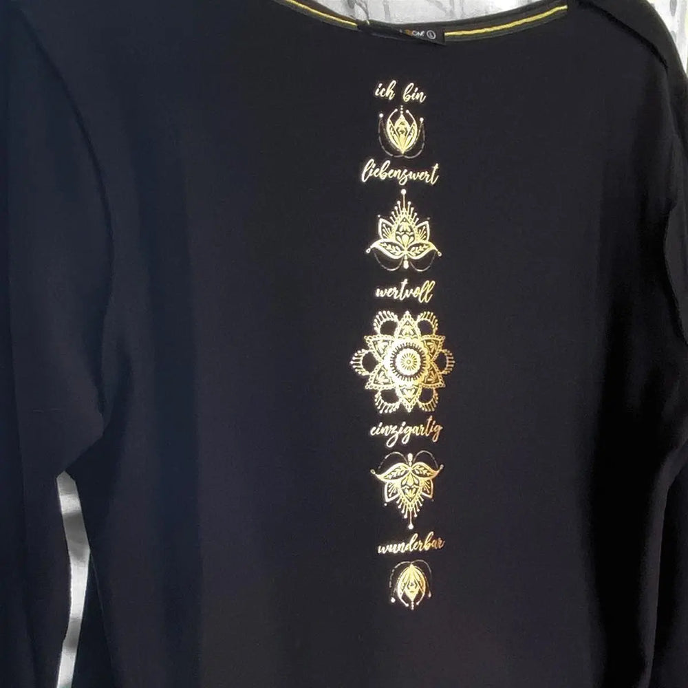 
                  
                    Innenseite des Shirts mit Affirmation am Rücken mittig zentriert in goldenem Aufdruck
                  
                